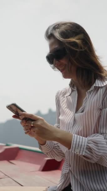 Asijská Žena Slunečními Brýlemi Podívá Svůj Mobilní Telefon Usměje Vertikální — Stock video