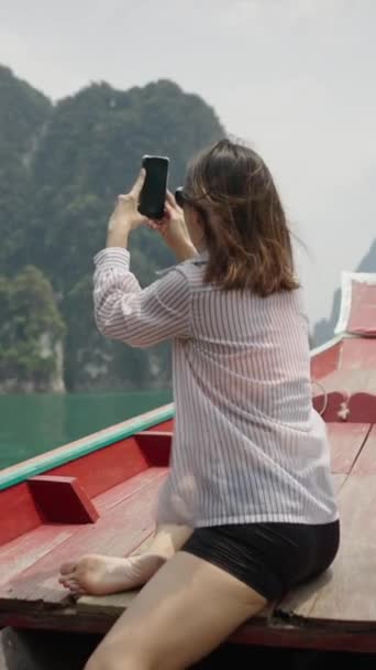 在一艘木船上 一位妇女拍摄了湖面的照片 垂直1080视频 — 图库视频影像