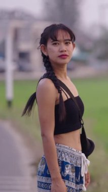 Taylandlı bir kız pirinç tarlalarının yanında güler FHD dikey video