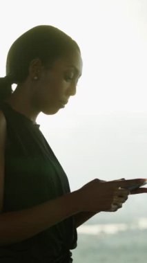 Siyah dijital göçebe kadın çatıdaki spor salonunda eğitim uygulaması kullanıyor - yaşam tarzı konsepti - FHD dikey video