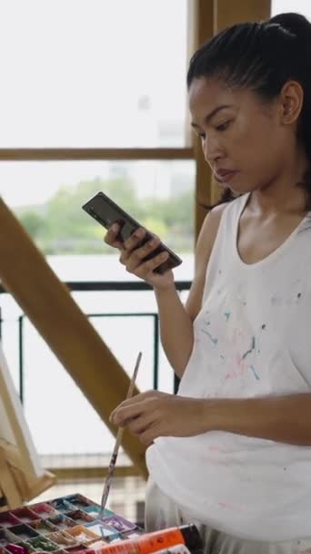 スマートフォンは美しい画家女性に見られます Fhd垂直芸術コンセプト — ストック動画