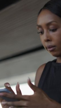Genç bir kadın akıllı telefonuyla eğitim programını izlerken koşu bandı konseptini kullanıyor - FHD dikey video