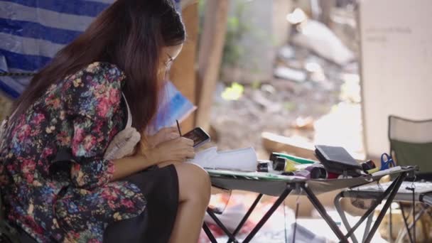 Una Mujer Morena Pinta Zapato Mientras Mira Teléfono Horizontal Video — Vídeos de Stock