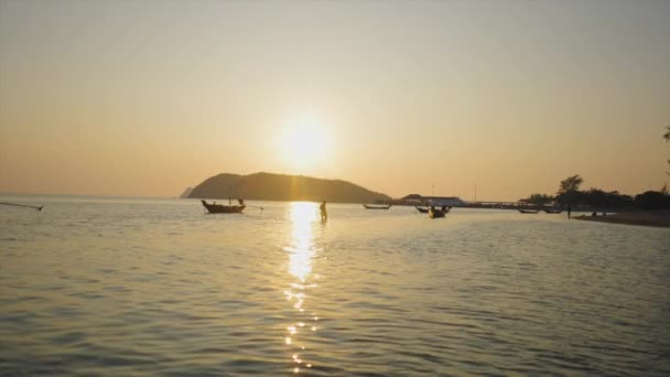 距離では 人が日没で水の中を歩く 4K水平ビデオ — ストック動画