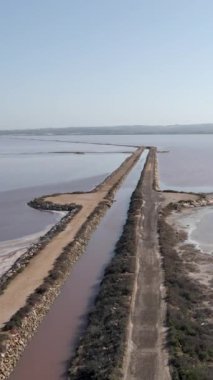 İspanya, Alicante, Torrevieja 'daki Salt Lake üzerindeki Salinas Kanalı üzerinde uçan insansız hava aracı. hava - Dikey 1080 video