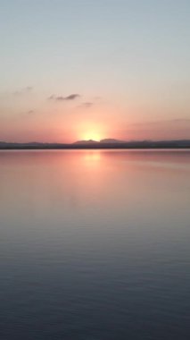 İspanya 'nın Alicante ilindeki Las Salinas de Torrevieja' daki Serene Gölü üzerinde güzel bir günbatımı. Geniş Görüntü - Dikey 1080 video
