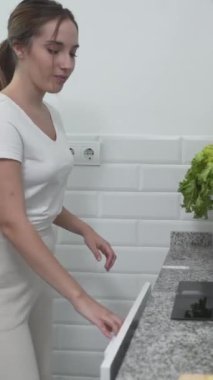 Tahta panoda doğranmış sebzeler pişirme kabına aktarılıyor. Yakın plan - Dikey