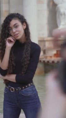 Dışarıdaki Faslı genç bir bayanın fotoğraflarını çeken bir erkek fotoğrafçı tarafından çekilen kamera. raf odağı - Dikey