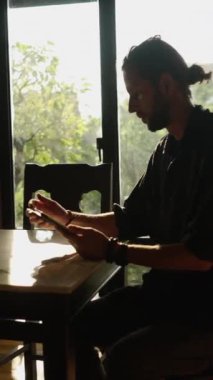 Batılı çocuk tabletine bakar ve pencerenin yanındaki bir şeyi işaretler - FHD dikey video