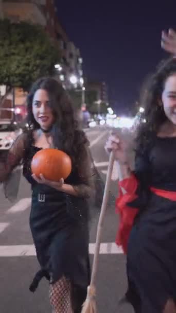 ハロウィーンの衣装を着て空の道を歩いている2人の可愛い女の子 移動媒体ショット 垂直1080 — ストック動画