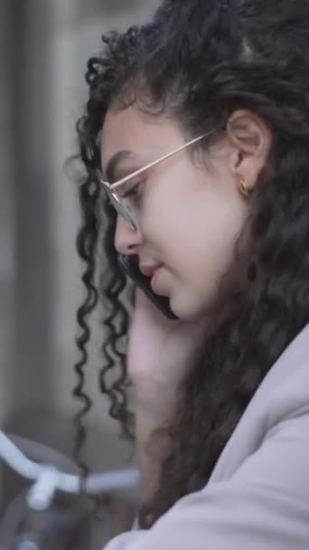 Длинноволосая Марокканская Девушка Смотрит Свои Наручные Часы Разговаривая Смартфону Увеличение — стоковое видео