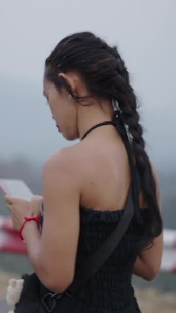 Meisje Met Een Paardenstaart Gekleed Zwart Kijkt Naar Haar Mobiele — Stockvideo