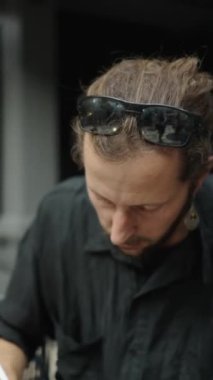 Avluda tablete resim çizen siyah gömlekli adam - FHD dikey video