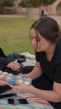 Makyaj rengi paleti tutan genç kızlar hangisini seçeceklerini tartışıyorlar - Dikey 1080 video