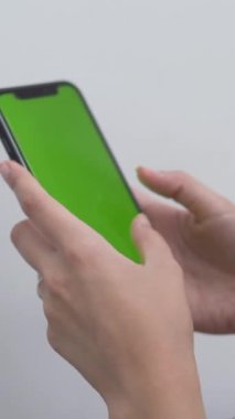 Cep telefonunda yeşil ekranlı bir kadın daktilo ediyor. - Kapat - Dikey