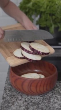 Mutfakta patlıcan doğrayan bir kız var. - Kapat - Dikey