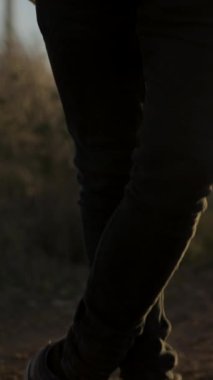 Çekici Sakallı Kafkas adam, gitarla ayakta duruyor ve gün batımından sonra kameraya bakıyor.