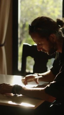 At kuyruklu yetişkin adam tablete bir şey çiziyor FHD dikey video.