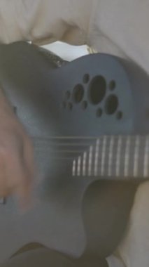 Açık havada gitar çalan ve güneş ışığına karşı şarkı söyleyen İspanyol adam - Dikey FullHD videosu