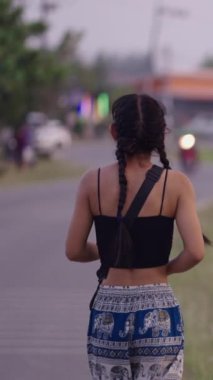 Asyalı kız yürürken kamerayı gördüğünde gülümser - FHD dikey video