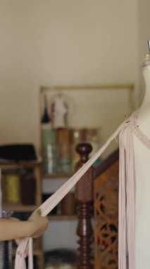 Tayland 'da yetişkin bir kadın tarafından ayarlanan bir mankenin üzerindeki elbise - FHD dikey video
