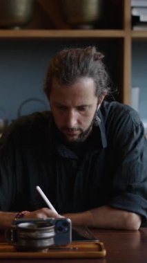 Batılı çocuk cep telefonuna bakar ve tabletine FHD dikey video çizer.