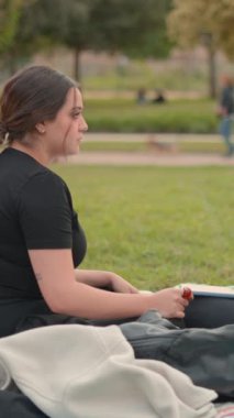 Kadınlar şehir parkında otururken boş zamanlarını sohbet ederek geçiriyorlar. Slomo çekimini zorla - Dikey 1080 video