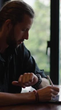 Adam tabletine FHD dikey video yazarken video görüşmesi yapıyor.