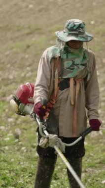 Taylandlı adam budama makinesiyle çalışıyor - FHD dikey video