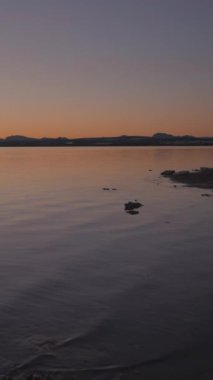  Altın gün batımında Torrevieja Pembe gölü kıyısı, Alicante, İspanya - sola dönüyor - Dikey FullHD videosu