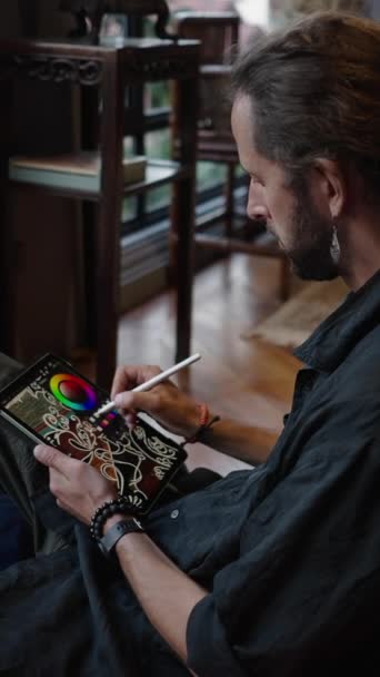 Sottile Ragazzo Bohemien Disegna Qualcosa Sul Suo Tablet Mentre Siede — Video Stock