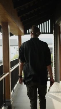 At kuyruklu ve sakallı bir adam tabletine bakmak için duruyor.