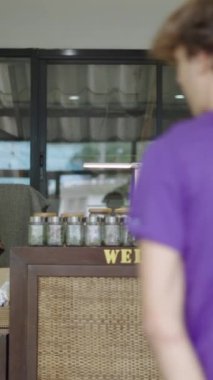 Bir satıcı içeri giren iki müşteriyle ilgilenir - FullHD dikey video