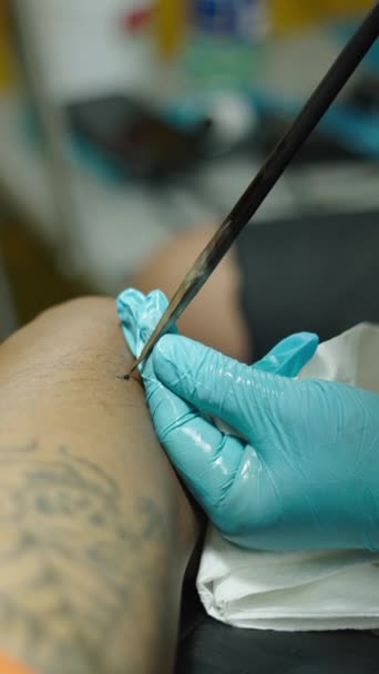 クライアント足にタトゥーを実行する伝統的なタトゥーアーティストのクローズアップショット クリエイティブコンセプト Fhd垂直ビデオ — ストック動画