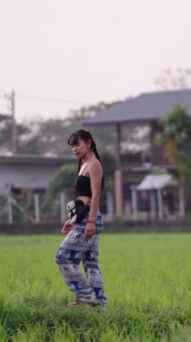 İki örgülü kız Asya 'da bir tarlada yürüyor - FHD dikey video