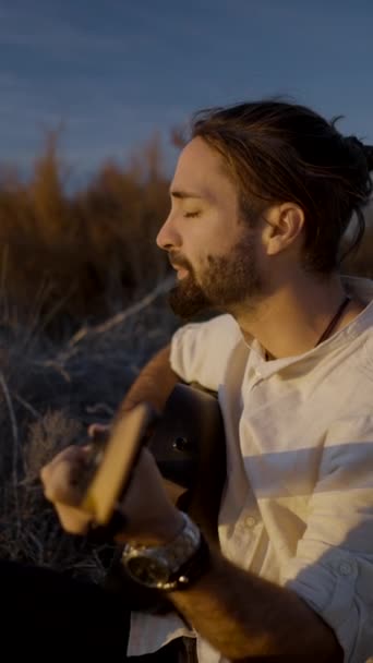 Erkek Müzisyen Sonbaharda Günbatımı Sahasında Gitar Çalıp Şarkı Söylüyor Dikey — Stok video