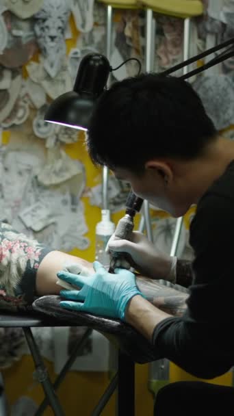 Azjatycki Tatuażysta Robi Tatuaż Leżącemu Klientowi Studiu Creative Concept Fhd — Wideo stockowe