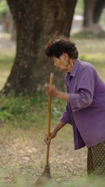 タイの森の床を掃除する女性 Fhd 垂直ビデオ — ストック動画