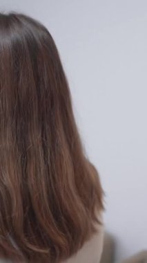 Modern bir evde tepsiyi elektrikli ocağın üzerine koyan güzel bir kız. Orta Çekim - Dikey