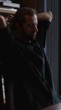 Düşünceli bir tasarımcı bir ofiste tabletine bakar - FHD dikey video