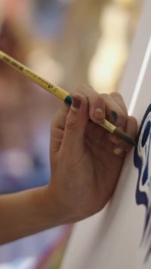 Kadın elleri yeşil ve mavi bir illüstrasyon çizer - FHD dikey video