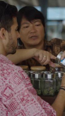 Bir satıcı müşterilerin FullHD dikey videoyu koklaması için bir kavanoz açar.