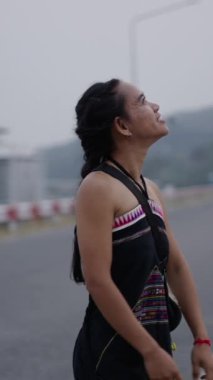 Genç bir kadın yolda yürüyor ve kollarını açıyor - 4K Yatay Yaşam Videosu