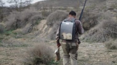 Tavşan taşıyan tanınmayan bir avcı - 4K Yatay video