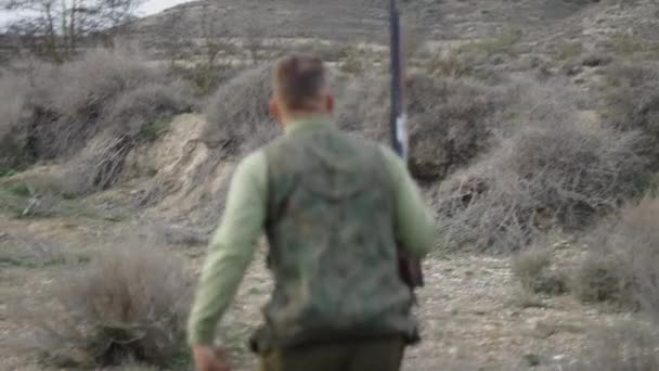 Cazador Camina Hacia Atrás Con Rifle Conejo Horizontal Video — Vídeos de Stock