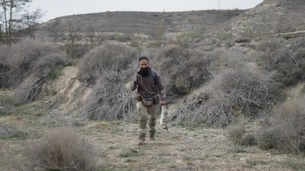 Ein Jäger Mit Einem Gewehr Und Seinem Kaninchen Nähert Sich — Stockvideo