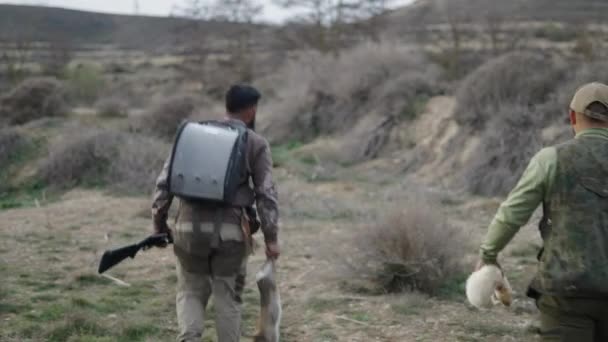 Due Cacciatori Irriconoscibili Che Camminano Con Coniglio Furetto Video Orizzontale — Video Stock