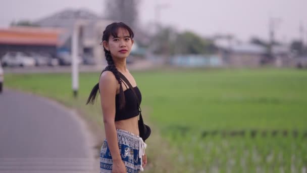 Een Thais Meisje Lacht Een Weg Naast Een Aantal Rijstvelden — Stockvideo