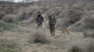 İki avcı bir köpek ve yaya bir gelincik - 4K Yatay video