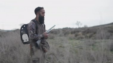 Uzun sakallı bir avcı avına ateş eder - 4K Yatay video